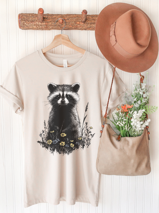 T-Shirt mit Waschbärmotiv in Wildblumenwiese - naturinspiriertes Design von SimpleLore